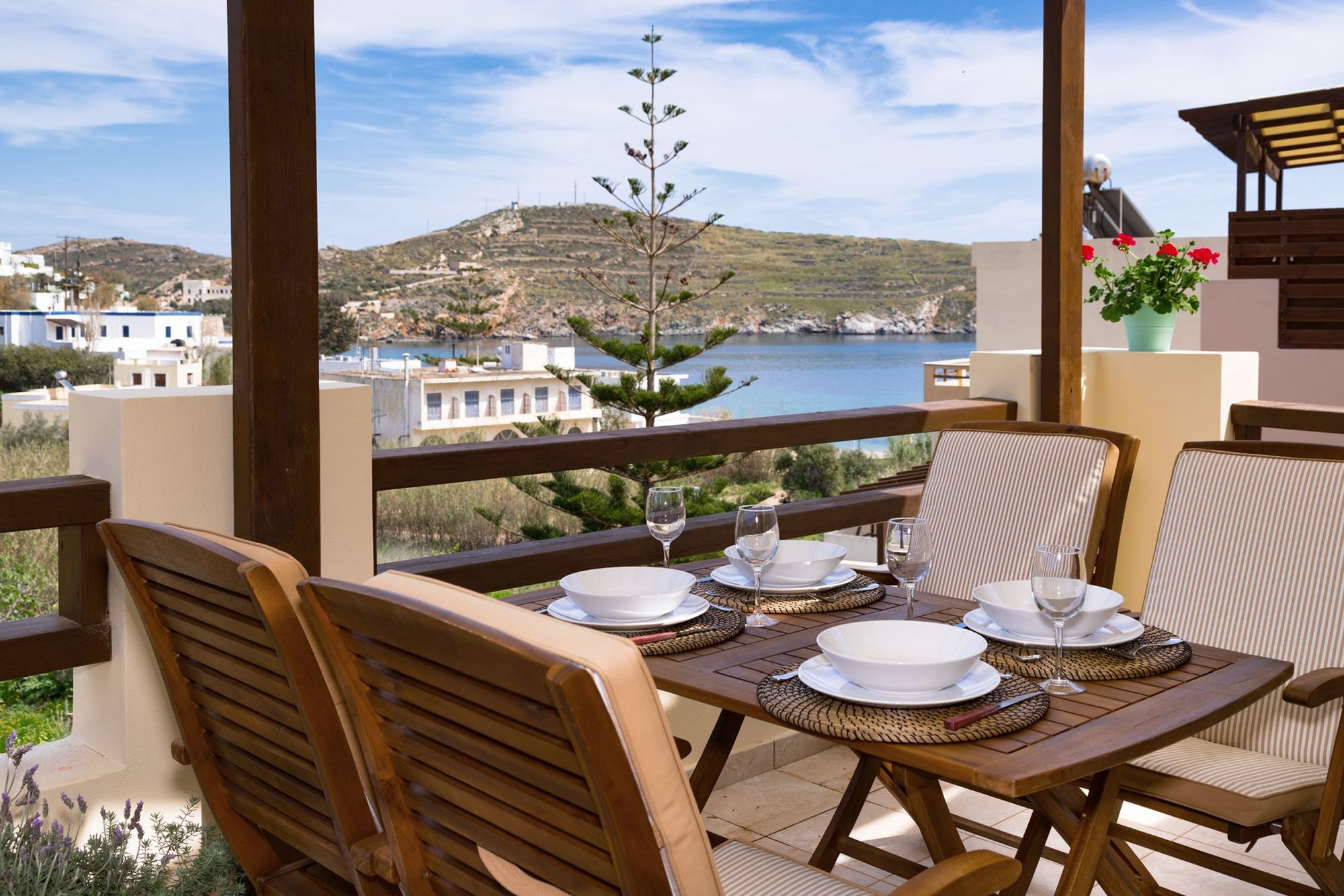 Dining table with white dinnerware at a sea view veranda.