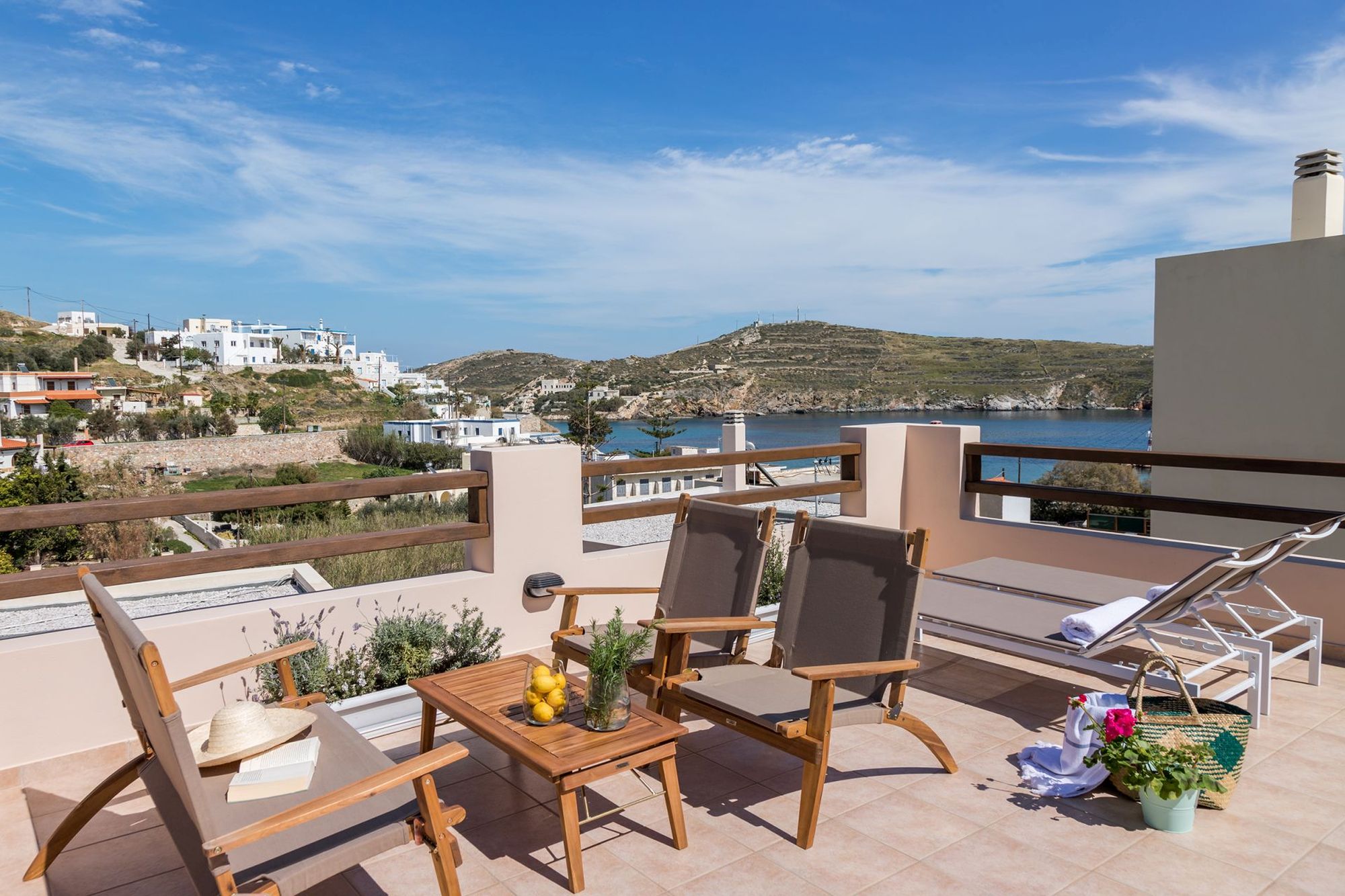 Spacious sea view veranda with lounge, two sunbeds and flowerpots.