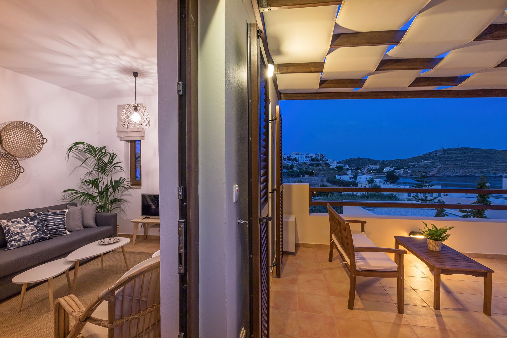 Part of the living room and the veranda of a Syra Suite residence, nicely decorated both in boho style.