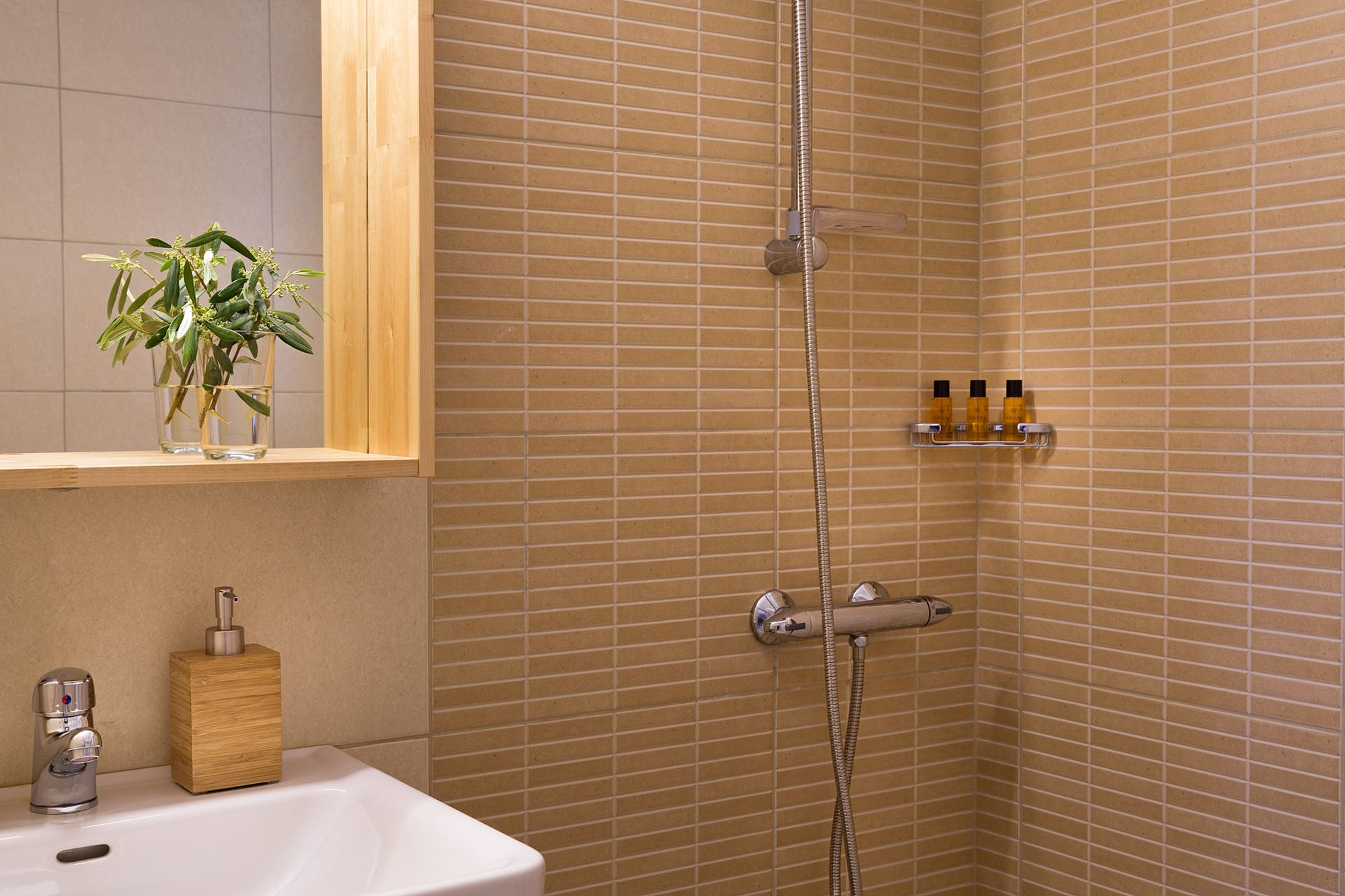 Beige modern bathroom with shower, a white washbasin and a mirror.